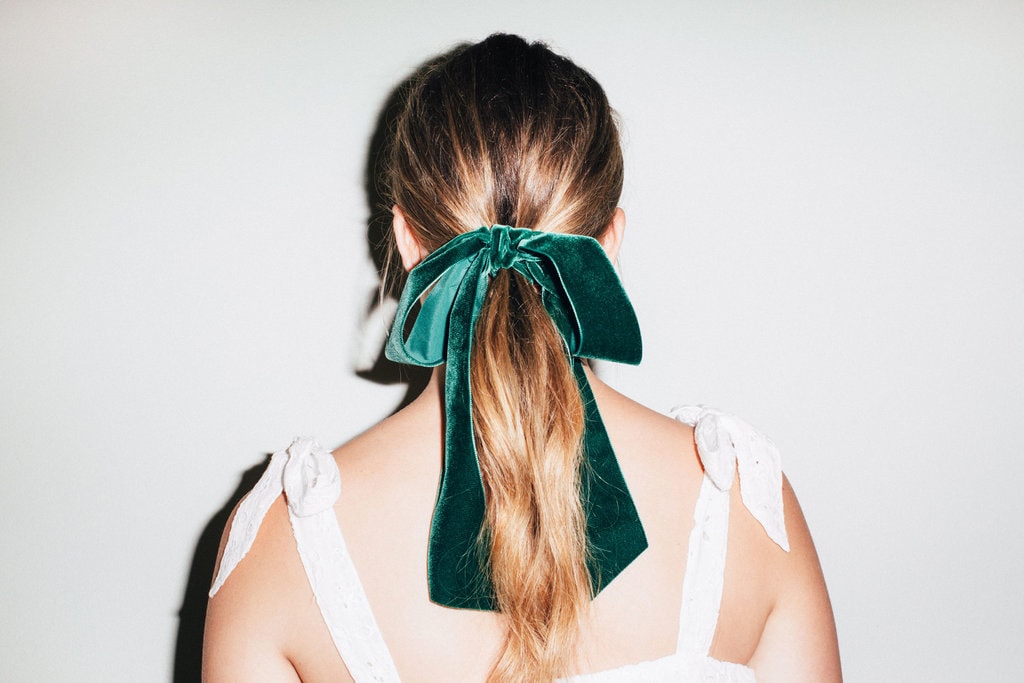 girl wearing a cashmere green hair bow in a ponytail