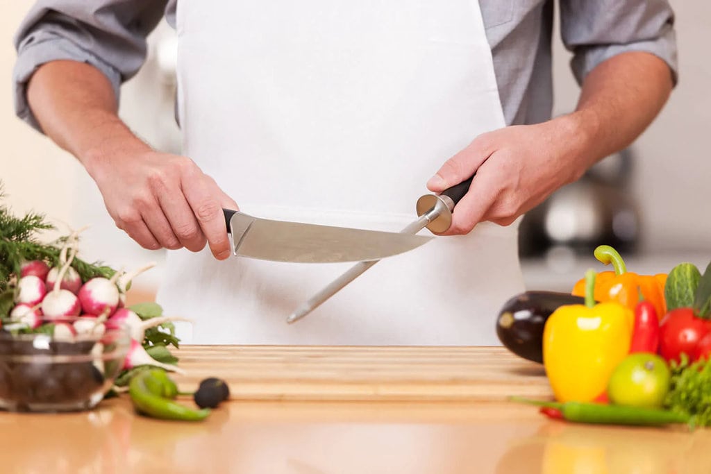 a home cook sharpening their knife befire cooking